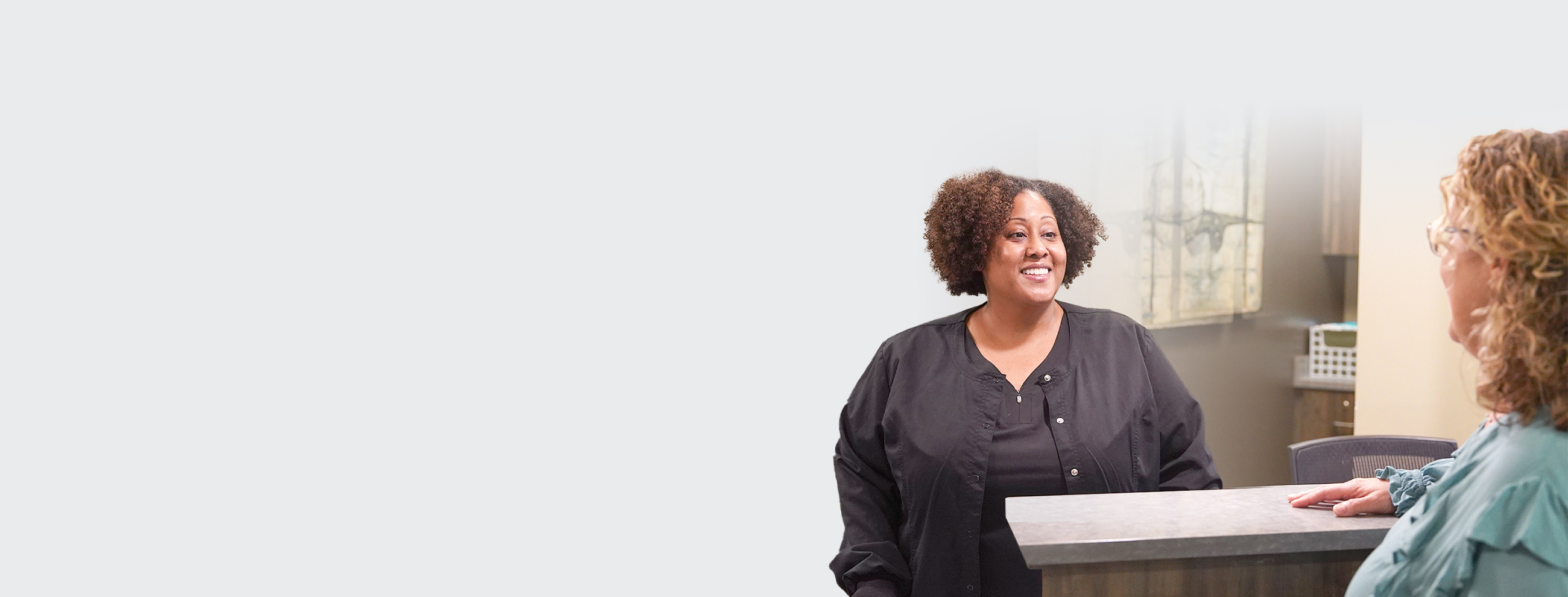 Two people talking at front desk
